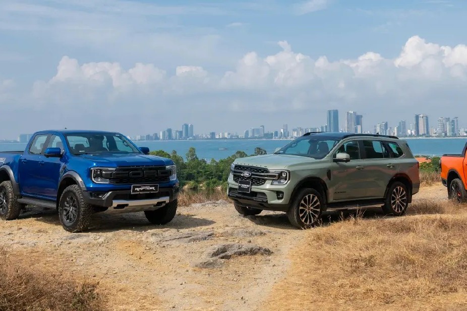 Ranger Raptor màu xanh, Everest màu xanh rêu và Ranger màu cam đỗ trên đồi nhìn ra thành phố ven biển